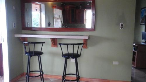 Golden GroveIslanders Place的厨房配有2把吧台凳和1面镜子