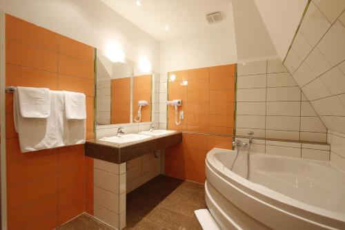 汉堡普罗伊斯达姆图帕莱斯酒店的带浴缸、水槽和浴缸的浴室