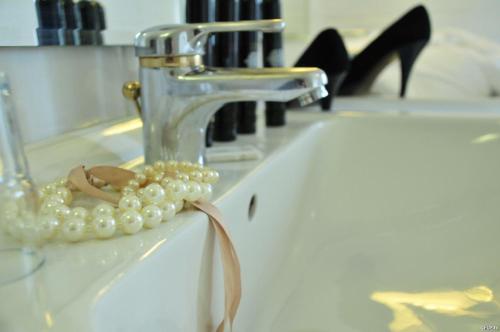 巴登-巴登豪斯莱歇特酒店的珍珠项链坐在水槽旁的水龙头旁