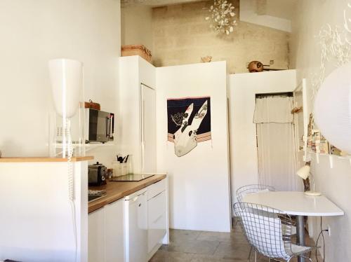 蒙彼利埃我的城市避难所 的厨房配有白色橱柜和白色桌子