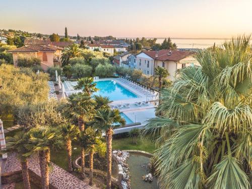 巴多利诺Hotel Villa Olivo Resort 3S的享有别墅的空中景致,设有游泳池和棕榈树