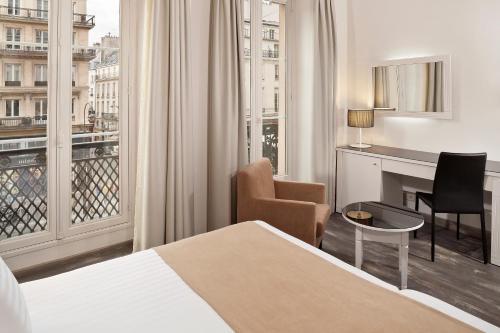巴黎Hotel Paris Opera Affiliated by Meliá的配有一张床、一张书桌和一扇窗户的酒店客房