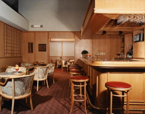 卡拉凯特奥贝尔格达莱伯酒店的一间带桌椅的餐厅和一间酒吧