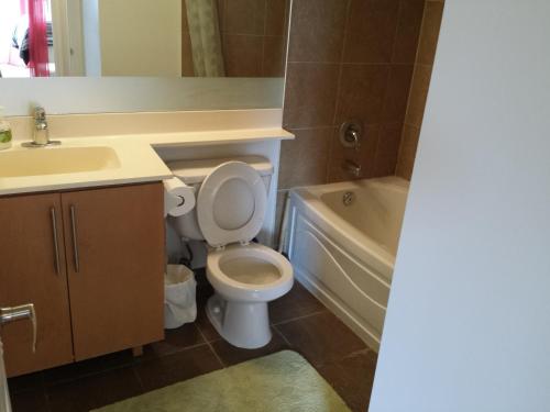 米西索加米西索加两卧室一浴室公寓的浴室配有卫生间、盥洗盆和浴缸。
