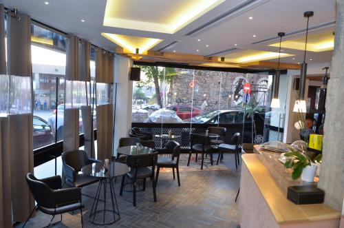 帕特雷阿多尼斯城市酒店的一间设有桌椅并享有街景的餐厅
