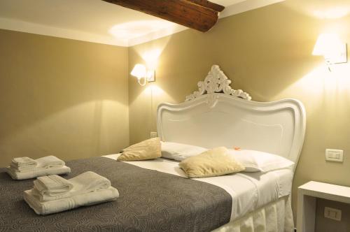 热那亚新诺德酒店的卧室配有白色床和毛巾