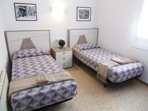 里贝斯的弗里瑟Apartament Nou Fontalba的一间卧室设有两张床和床头柜