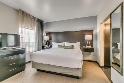 拉伯克Staybridge Suites Lubbock South, an IHG Hotel的一间卧室配有一张大床和电视
