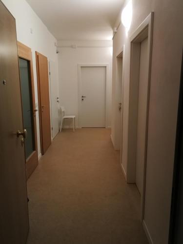 博尔扎诺Central Rooms的一条带两个门的空房间走廊
