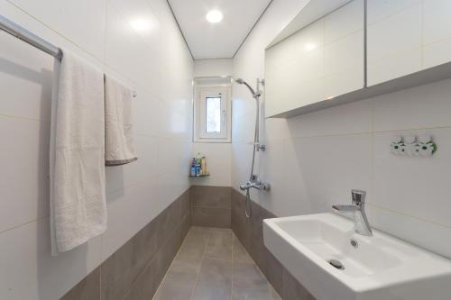 首尔金氏旅馆的白色的浴室设有水槽和淋浴。