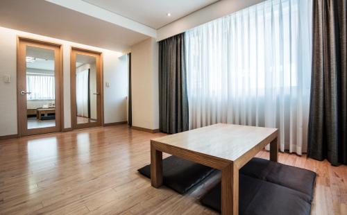 首尔首尔王子酒店的客厅配有木桌和窗户。