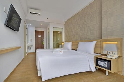 玛琅维兹普莱姆巴苏吉拉玛特玛琅酒店的卧室配有一张白色大床和电视。