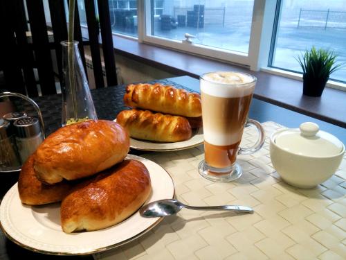 乌拉尔斯克Apartments DAF-Center的一张桌子,上面放着两盘面包和一杯咖啡