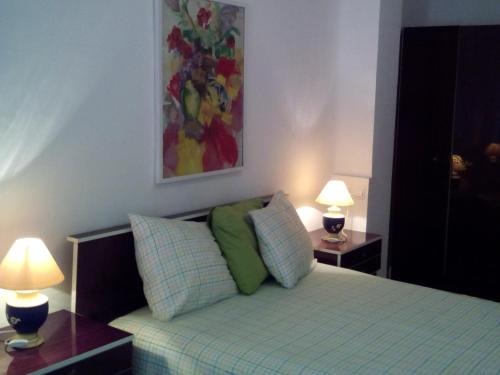 EsteponaHeart of Estepona的一间卧室配有一张带两张桌子和两盏灯的床。