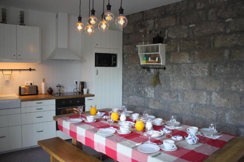 波瓦桑Casa da Cisaltina的厨房里配有一张桌子,上面放有盘子和橙子