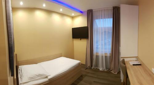 梅尔布施布德瑞酒店的一间卧室配有一张床、一张书桌和一个窗户。