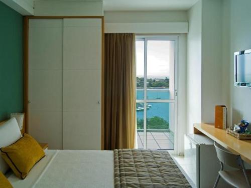 维多利亚Praia do Canto Apart Hotel的一间卧室设有一张床和一个滑动玻璃门