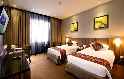 吉隆坡Hotel Royal Kuala Lumpur的酒店客房设有两张床和一台平面电视。
