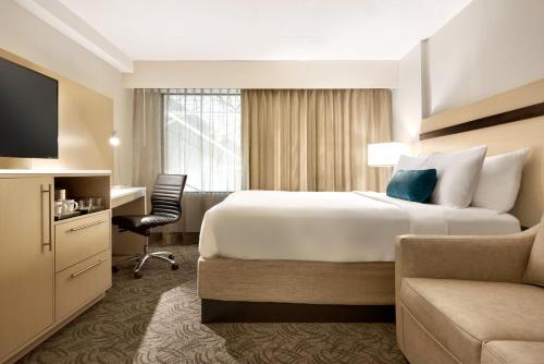 诺默尔Holiday Inn - Bloomington - Normal, an IHG Hotel的酒店客房设有一张大床和一张书桌。