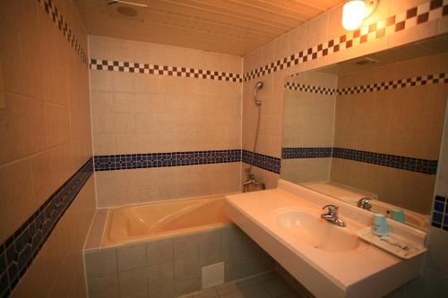 台南百威汽车旅馆的带浴缸、水槽和镜子的浴室