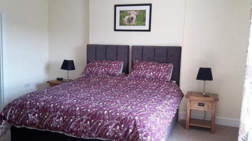 佩特沃斯基尔沙姆农场住宿加早餐旅馆的一间卧室配有一张带紫色棉被的床
