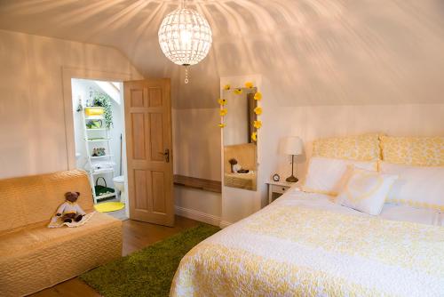 莫维尔Cherrytree House B&B的一间卧室配有一张床、一张沙发和一个吊灯。