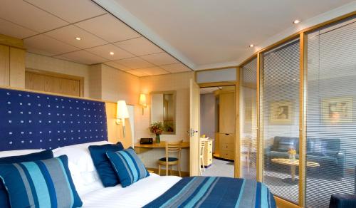 博尔顿Bolton Stadium Hotel的酒店的客房 - 带蓝色和白色枕头的床