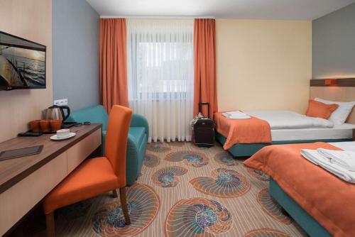 加茨比亚格拉Malvis Vacation House的酒店客房配有两张床和一张书桌