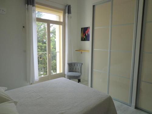 卡瓦永Domaine Les Rivales的一间卧室设有一张床、一个窗口和一把椅子