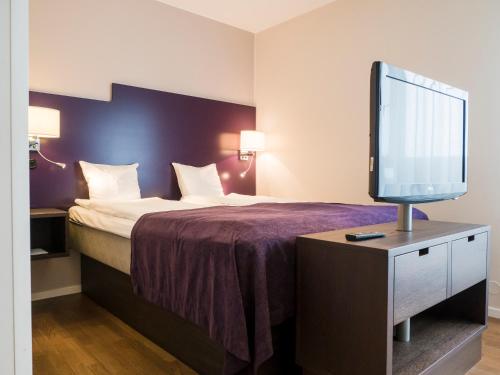 隆德Finn Apartments的配有一张床和一台平面电视的酒店客房