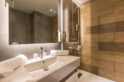 日内瓦日内瓦帕尔展览中心机场宜必思尚品酒店的浴室设有白色水槽和镜子