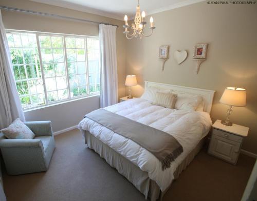 格拉罕镇AppleBee Guest Cottages的卧室配有一张白色大床和吊灯。