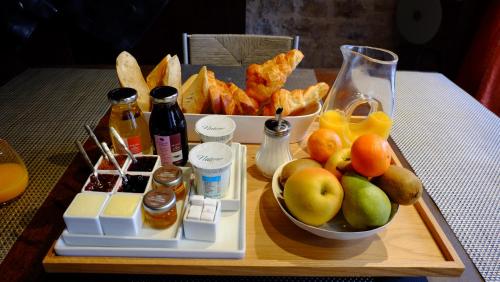 Chassagne-Montrachet沙萨尼蒙特拉谢城堡酒店的桌上的水果和小吃托盘