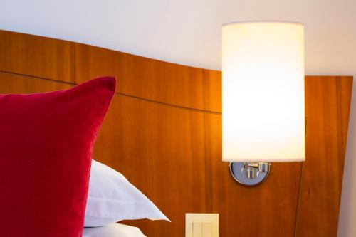 巴黎欧洲巴黎埃菲尔酒店的红色枕头坐在床上,带灯