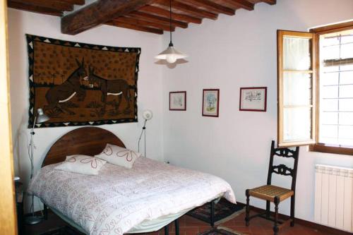 卡斯特利纳-因基安蒂Agriturismo capanna delle Cozzole的一间卧室配有一张床和一把椅子