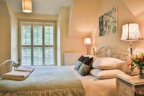Holford科姆豪斯酒店的卧室配有带枕头的床铺和窗户。