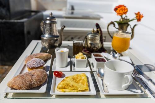 索维拉Riad MALAÏKA的一张桌子,上面放着两盘早餐食品和饮料