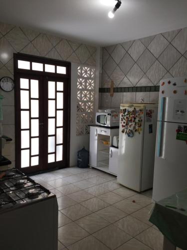 萨尔瓦多Linda casa na Praia do Flamengo的一间厨房,配有白色家电和大窗户
