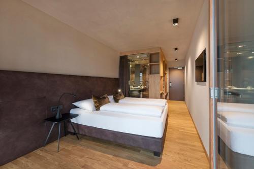 EglofsEllgass Allgäu Hotel的一间带白色大床的卧室和一间浴室
