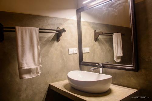 高尔Breeze Villa Unawatuna的浴室配有盥洗盆、镜子和毛巾