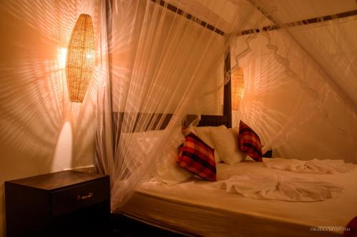 高尔Breeze Villa Unawatuna的卧室配有带蚊帐的床
