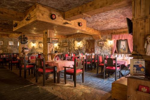 波德戈里察黑山楼酒店的餐厅拥有木墙和桌子以及红色椅子
