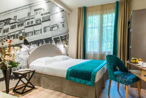 佛罗伦萨FH55 Grand Hotel Mediterraneo的酒店客房配有一张床、一张桌子和一把椅子。
