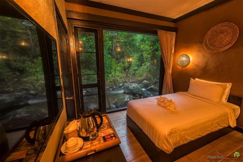 Ban Kat纳姆卡约拉霸度假村的一间卧室设有一张床和一个大窗户