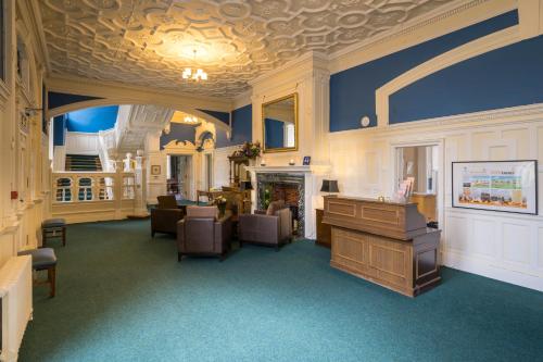 阿伯福伊尔Gartmore House Bed & Breakfast的客房设有带椅子和桌子的沙龙。