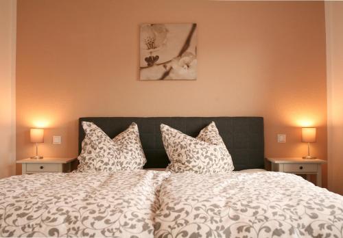 BergenHotel Piano的一间卧室配有一张带枕头的床和两盏灯。