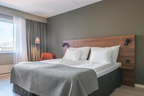 克里斯蒂安斯塔德克里斯蒂安斯塔德品质酒店的一间卧室配有一张大床和木制床头板