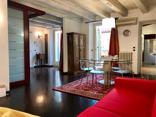 维罗纳圣尼科洛3号公寓的客厅配有红色的沙发和桌子