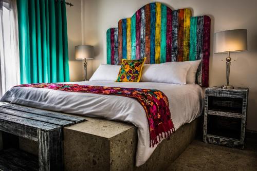 Ciudad ConstituciónMaría de Nadie "Hotel Boutique"的一间卧室配有一张大床和色彩缤纷的床头板