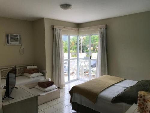 贝卢港Pousada Vila Verde的一间卧室设有两张床和滑动玻璃门